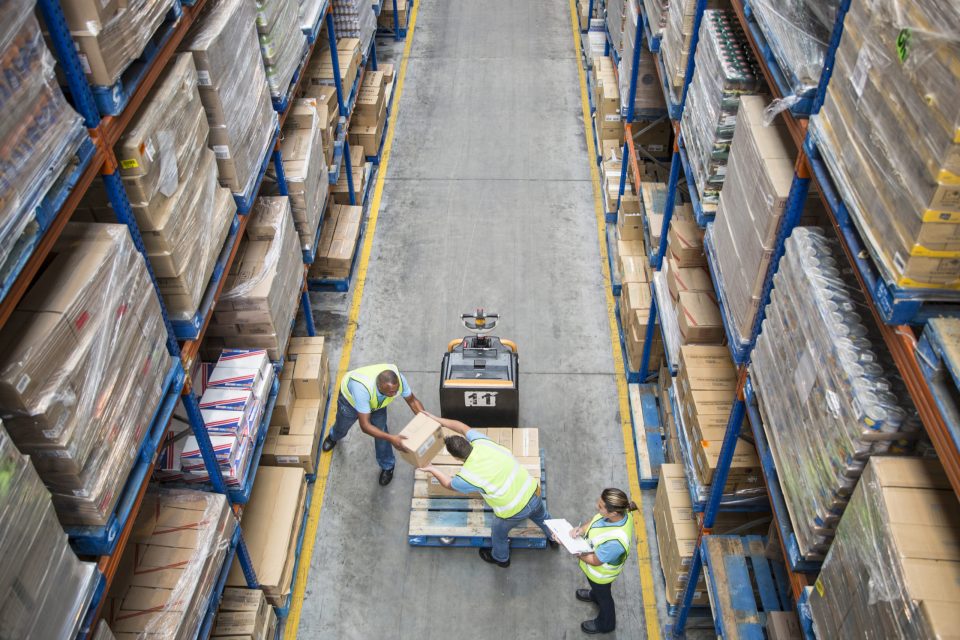 Workers unloading pallet inside a food distribution warehouse